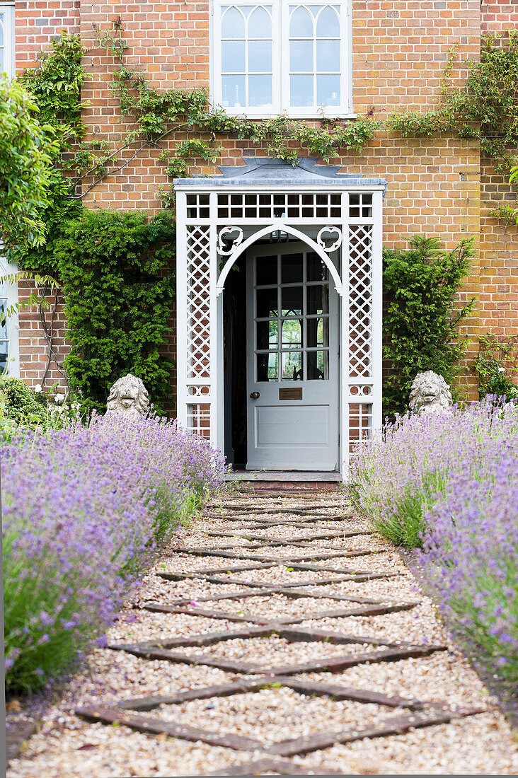 Kiesweg gesäumt von Lavendel zum Eingang eines Landhauses mit Portikus