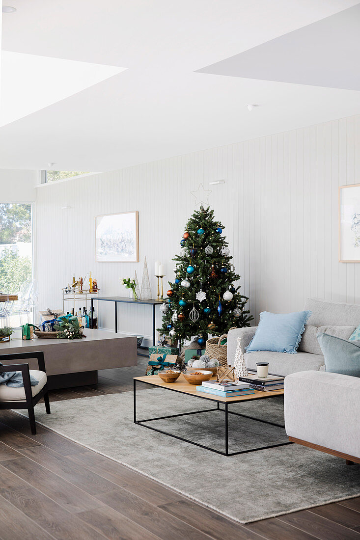 Weihnachtlich dekoriertes helles Wohnzimmer mit Sofa und Couchtisch