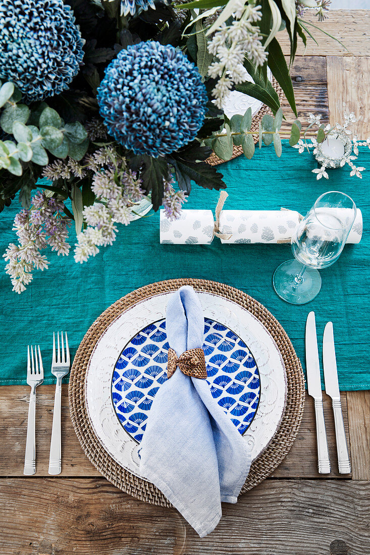 Gedeckter Tisch in Aquatöne mit Blumenschmuck und Tischläufer