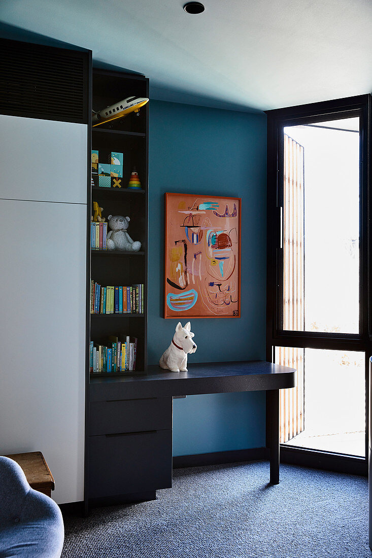 Einbauschrank und Schreibtisch im Kinderzimmer mit blauer Wand