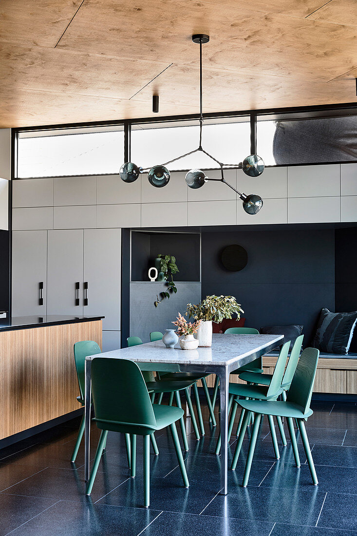 Grüne Stühle am Esstisch in der Wohnküche im Architektenhaus