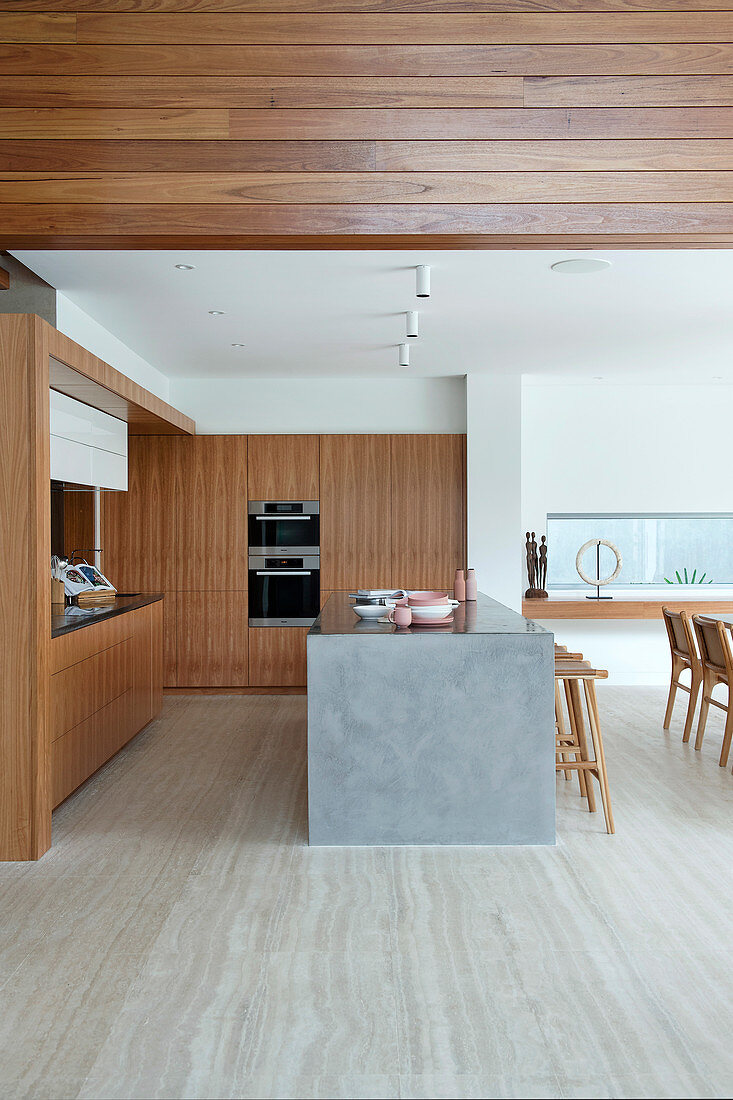 Offene Küche mit Holzverkleidung und Kücheninsel in Architektenhaus