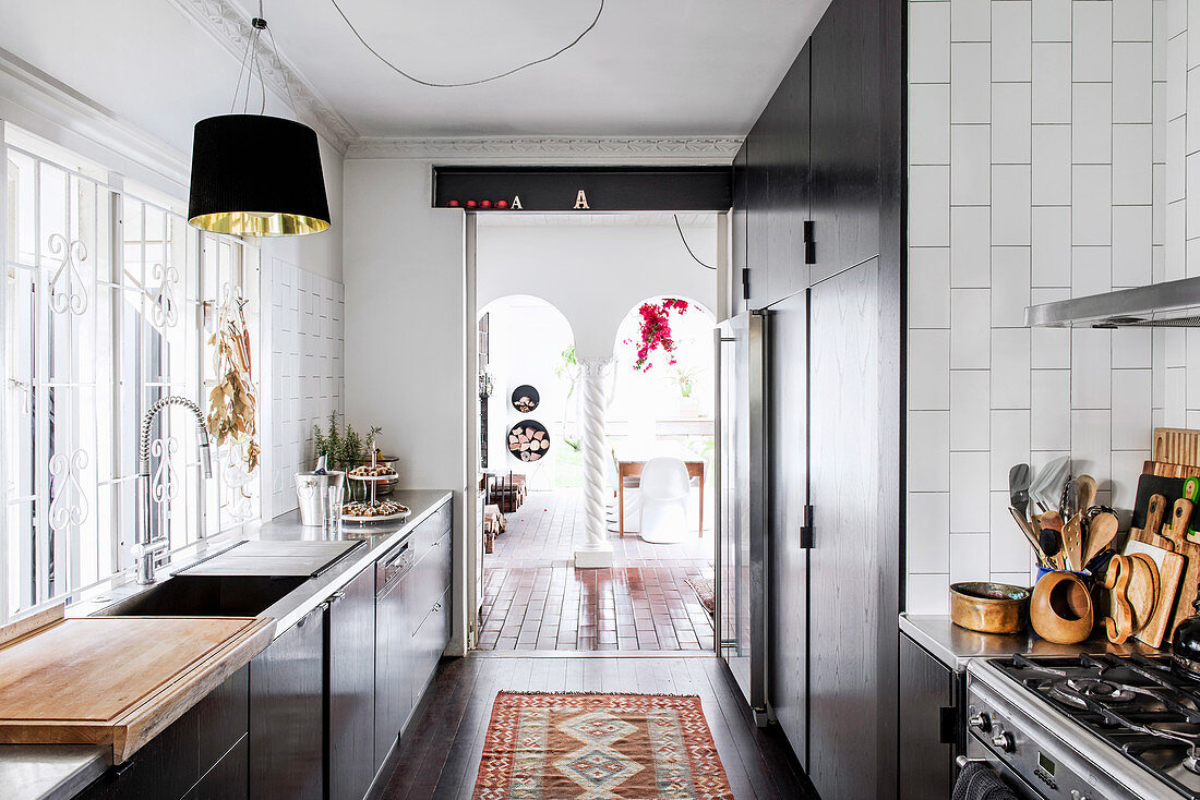 Küche mit Einbauschränken und weißen Wandfliesen