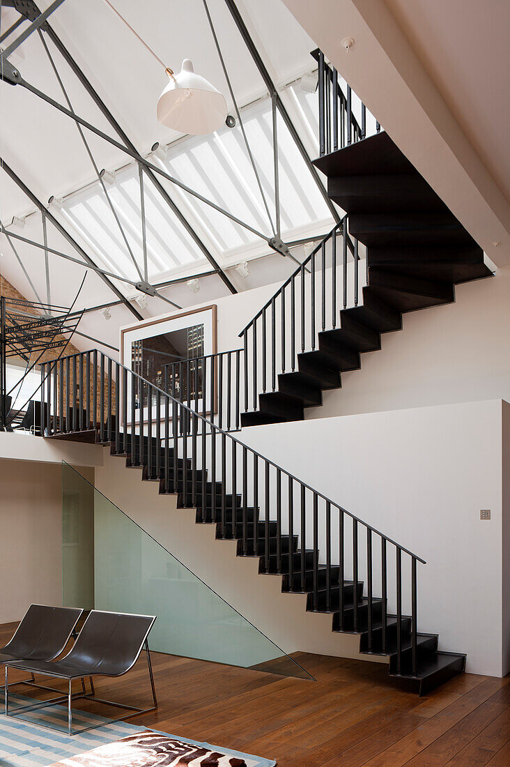 Black steel staircase and wrought iron cross-members in multi-storey loft apartment