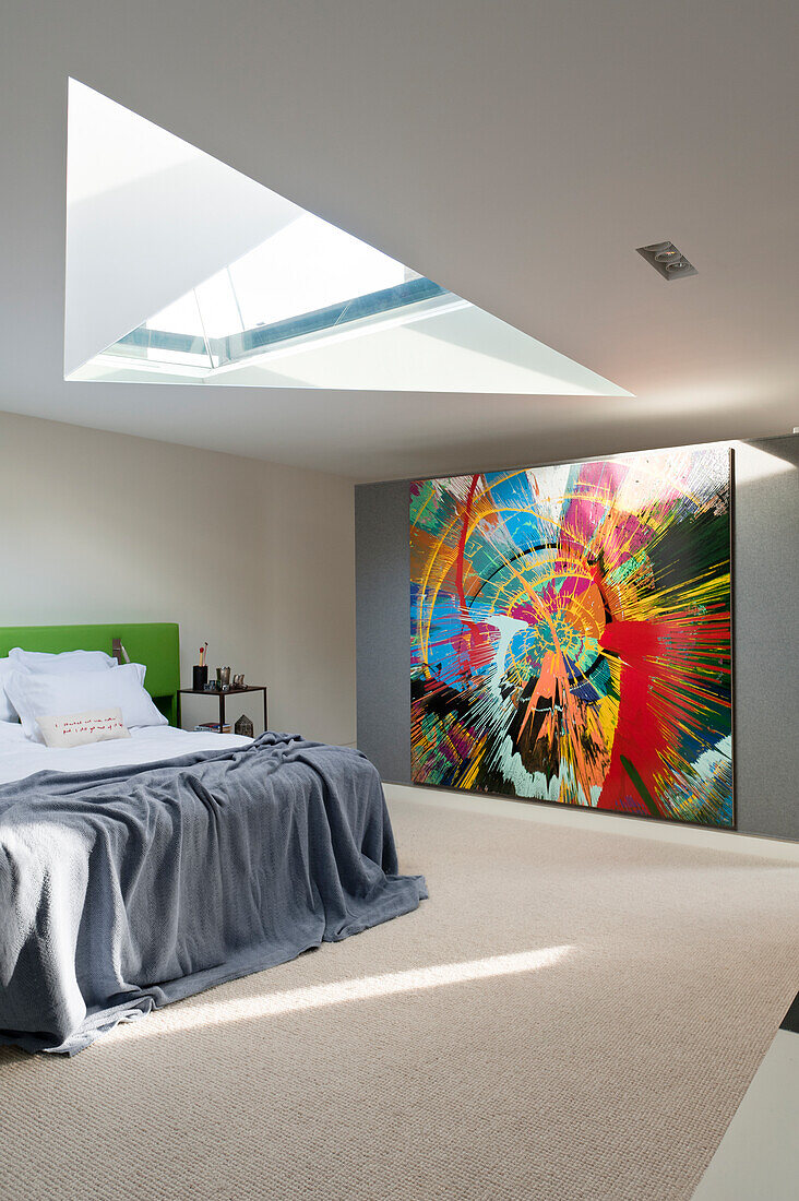 Huge abstract painting providing a splash of colour in minimalist bedroom