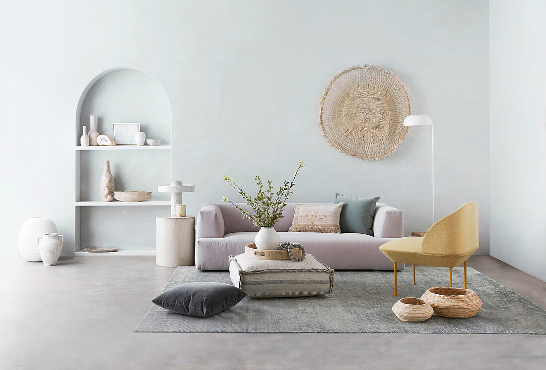 Living room decorated in muted colors with sofa next to arched wall niche