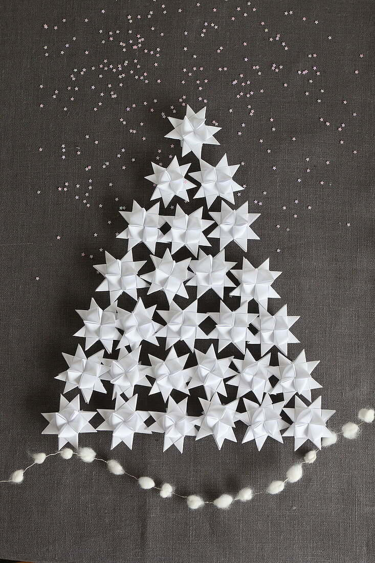 Christmas tree made from 3D origami stars on grey linen fabric