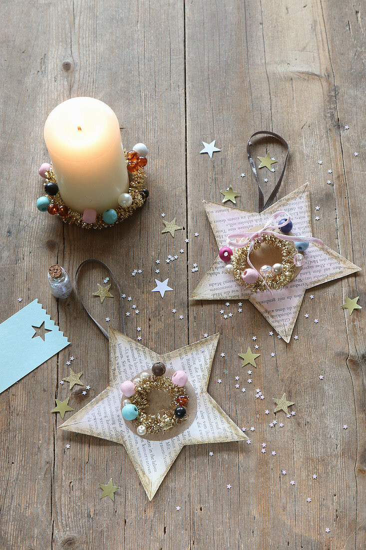 Christmas stars handcrafted from coloured book pages decorated with beads and glitter