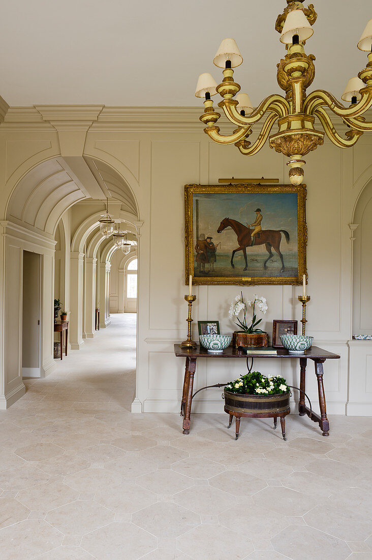 Sandstone flags and chandelier in foyer and arched passageway in English manor house