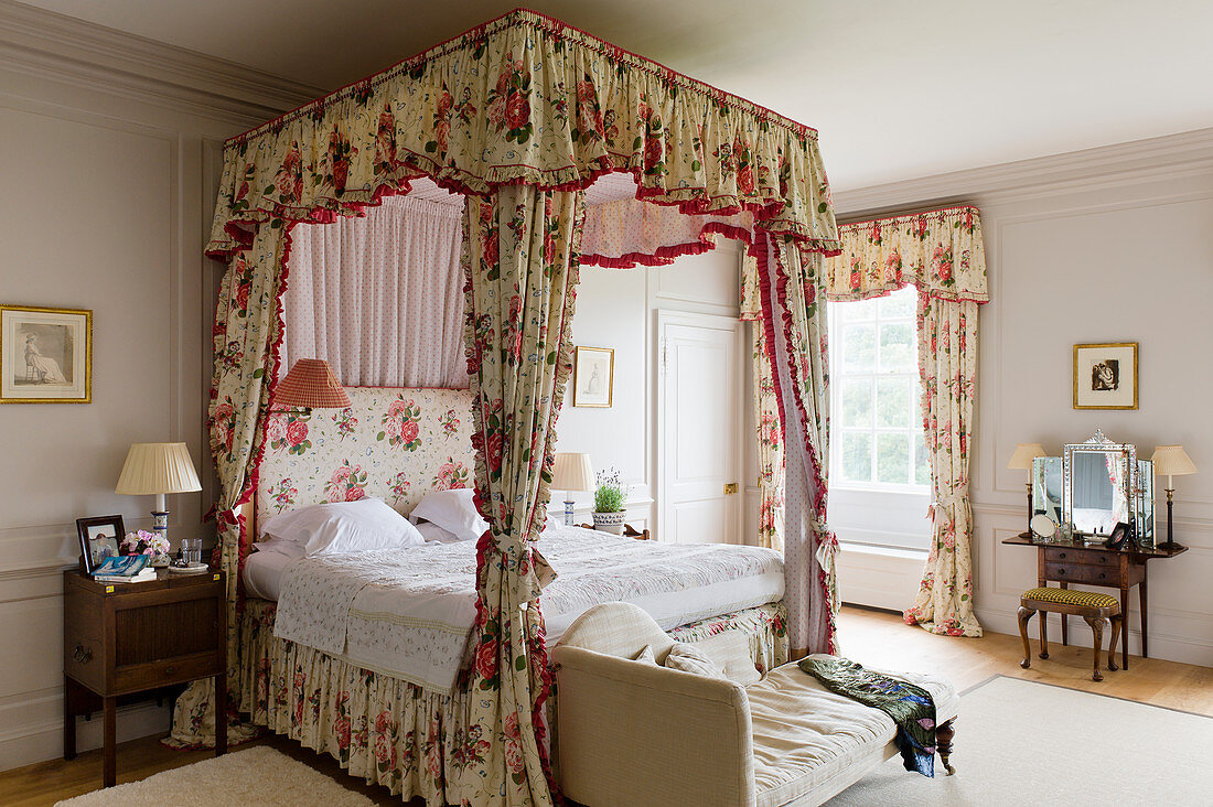 Himmelbett mit geblümten Chintz-Vorhängen in Schlafzimmer eines englischen Herrenhauses