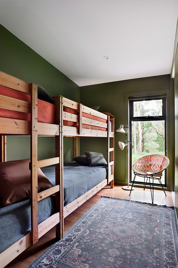 Two bunk beds in a narrow room with green walls