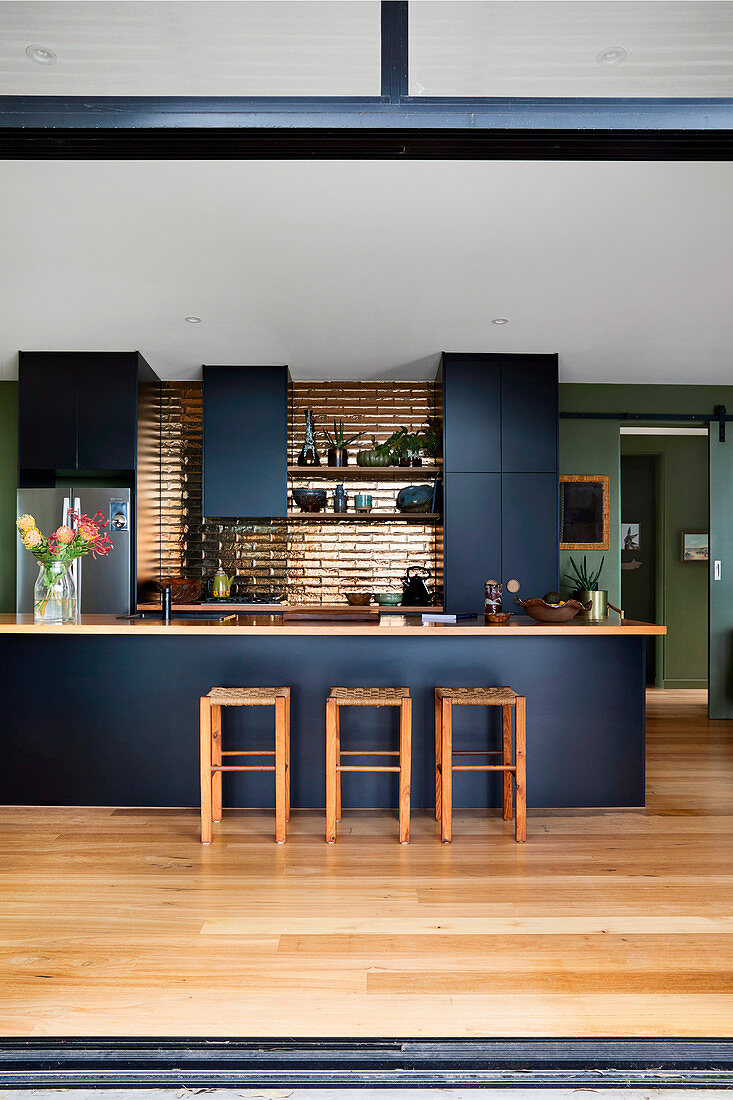 Open kitchen with black fronts and golden tiles