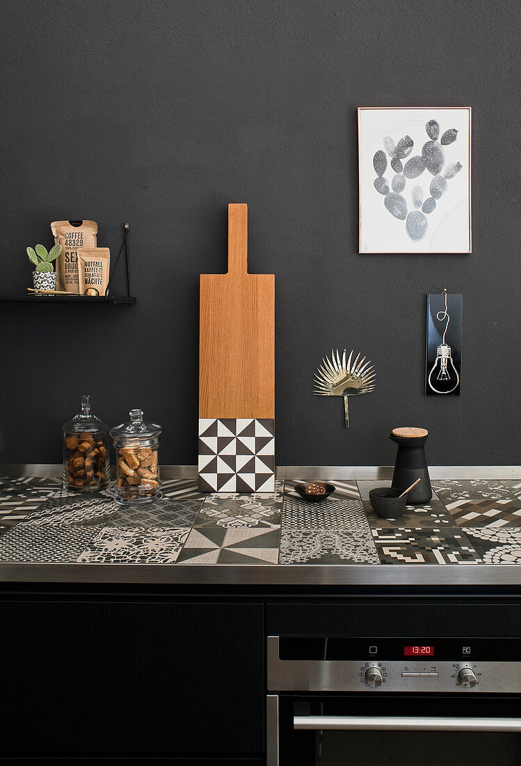 Tiled, black-and-white patterned worksurface in black kitchen
