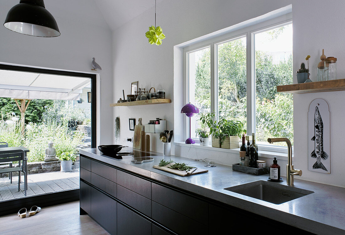 Küchenbereich mit schwarzer Küchenzeile und Zugang zur Terrasse