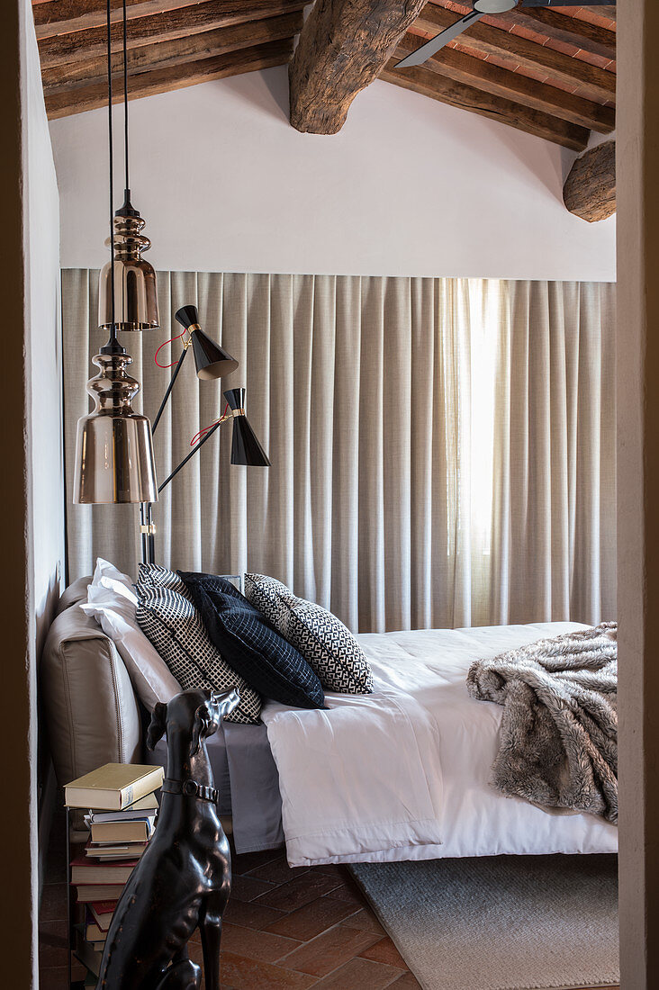 Bedroom in shades of grey with wooden ceiling beams