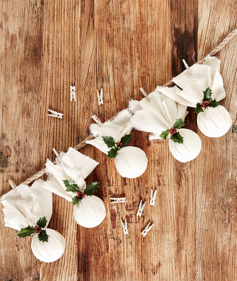 Garland of handmade Christmas pudding decorations wrapped in cloth