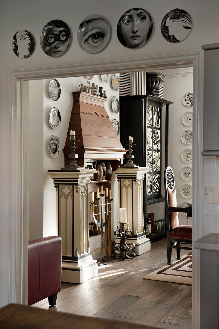 Wooden mantelpiece decorated with pillars, candlesticks and collection of plates
