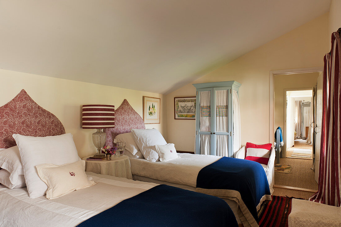 Zwei Einzelbetten, Kopfteile mit rotem Paisley-Bezug, im Schlafzimmer