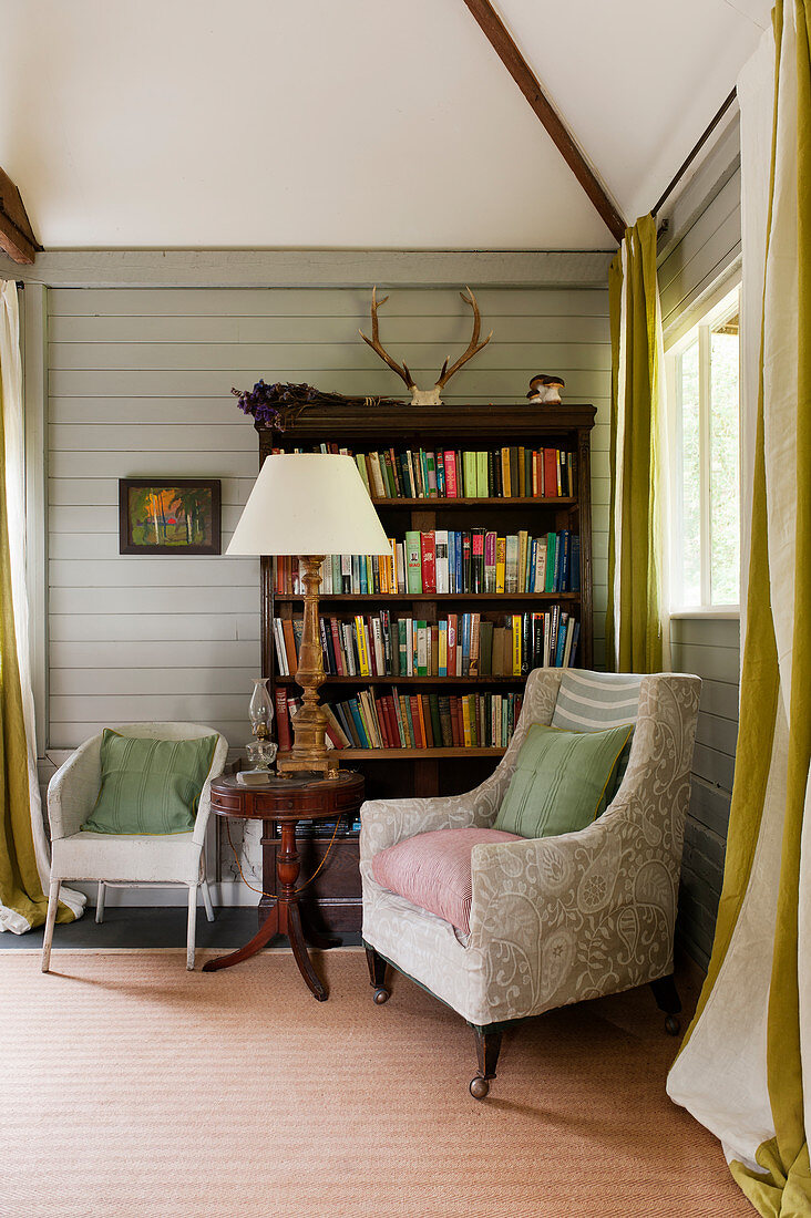 Bookshelf and seating area in cosy wood-clad interior