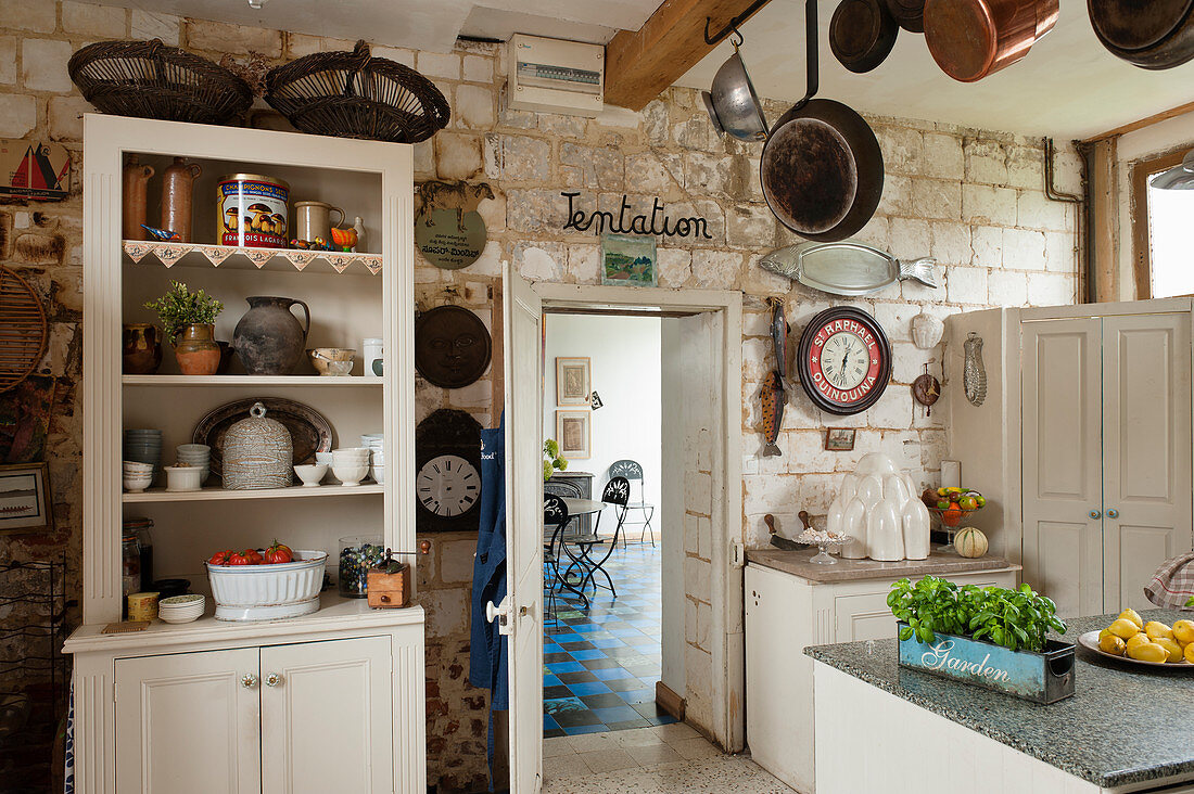 Buffetschrank in rustikaler Landhausküche mit Natursteinwand