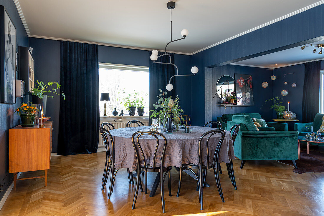 Dining area in open-plan interior with blue wall