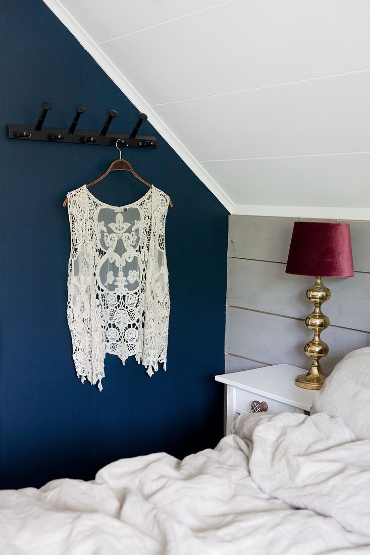 Spitzenweste an der Garderobe im Schlafzimmer mit blauer Wand