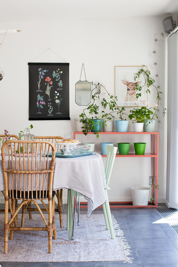 Rattanstühle am Tisch im Esszimmer in sommerlichen Pastellfarben