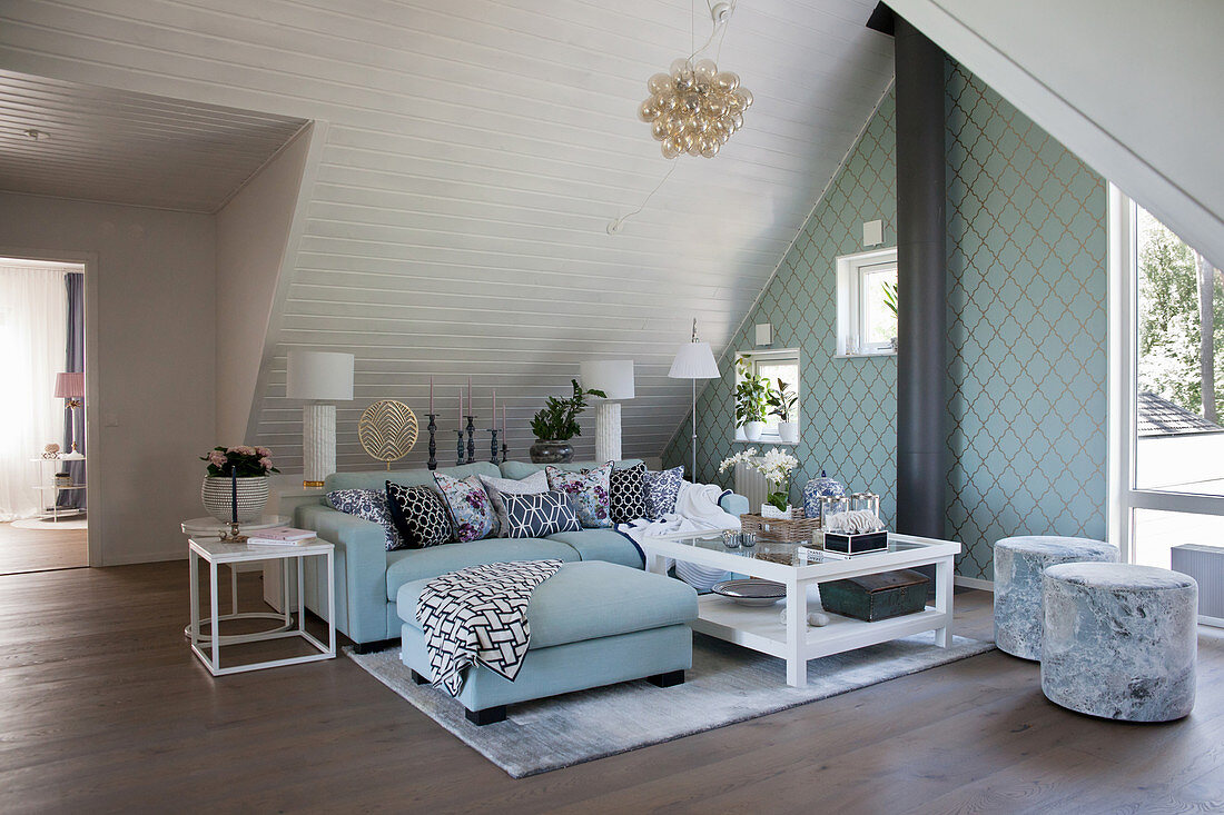 Elegantes Wohnzimmer in Weiß und Türkis unter der Dachschräge