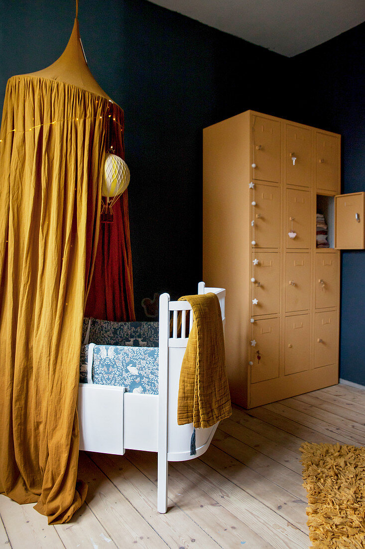 Kinderzimmer mit ockerfarbenem Dekor, blauen Wänden und hellem Holzboden