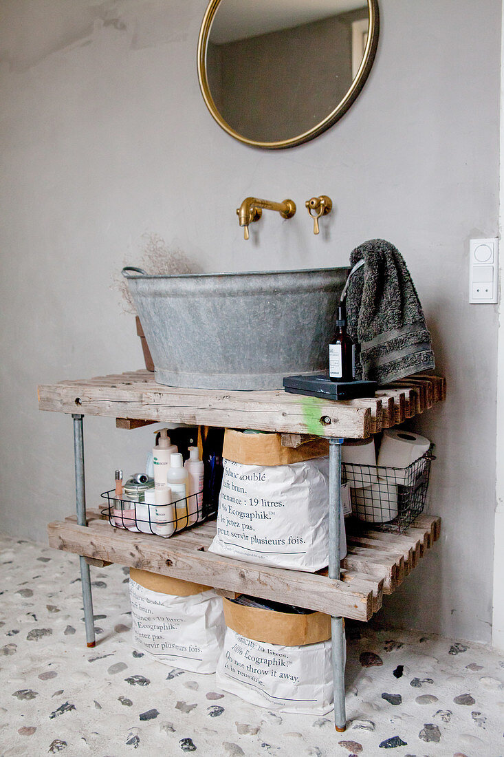 Sink made from rustic zinc tub on open wooden shelves in bathroom