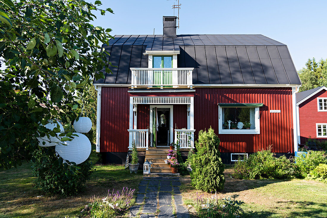 Rotes Schwedenhaus mit sommerlichem Vorgarten