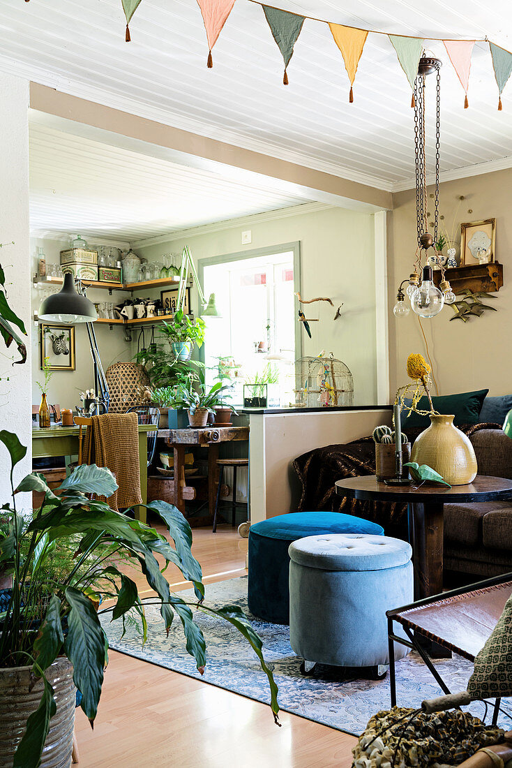 Offener Wohnraum im Vintagestil mit vielen Pflanzen und Brauntönen
