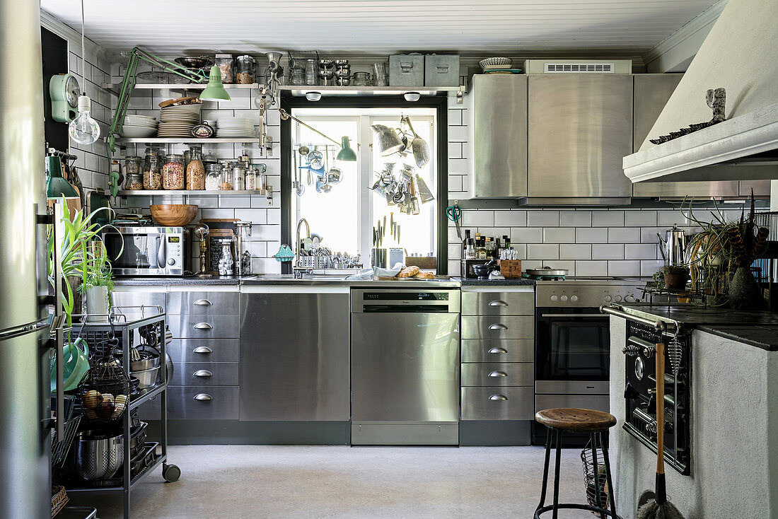 Stainless steel cabinets and traditional, wood-fired stove in large kitchen