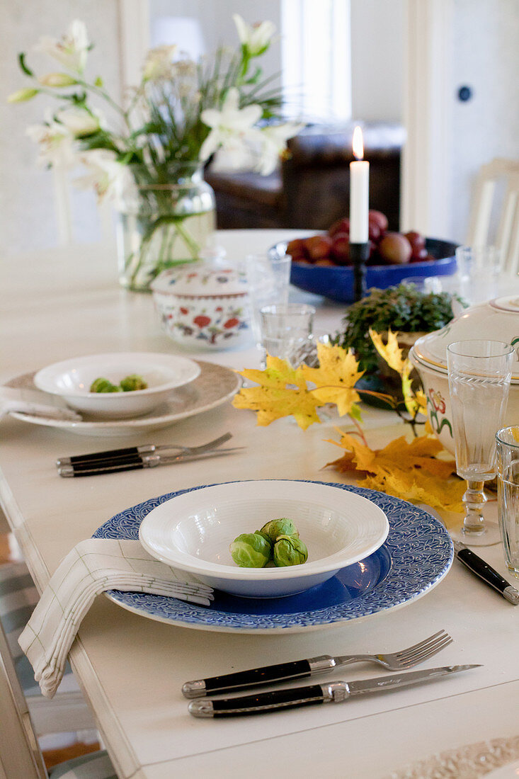 Herbstlich gedeckter Esstisch mit Blätterdekoration