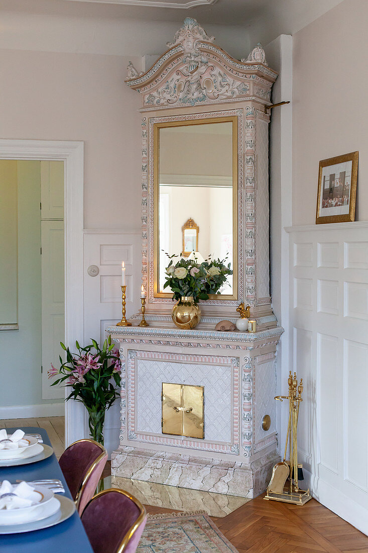 Antique tiled stove in grand interior with panelled walls