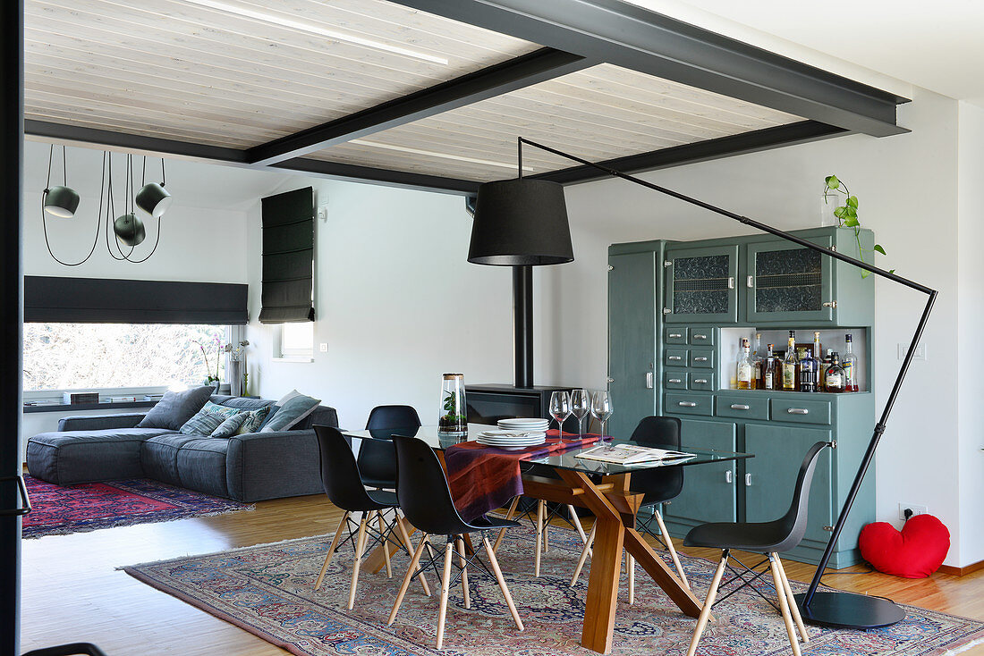 Sofa and dining table in open-plan loft apartment with steel joists