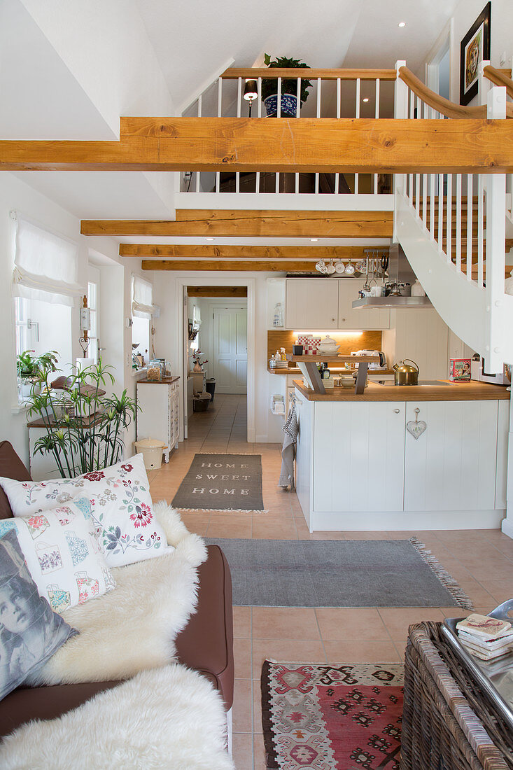 Offener Wohnraum mit Küche und Holzbalken in der offenen Decke