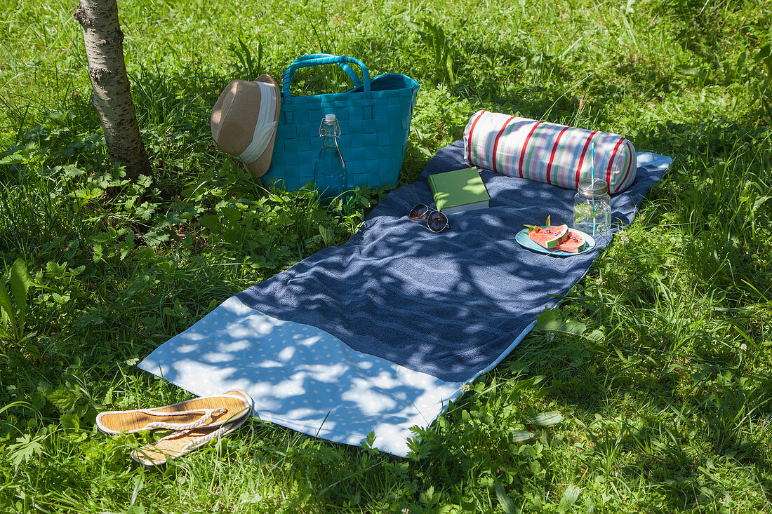 Bolster on hand-sewn sunbathing blanket on lawn