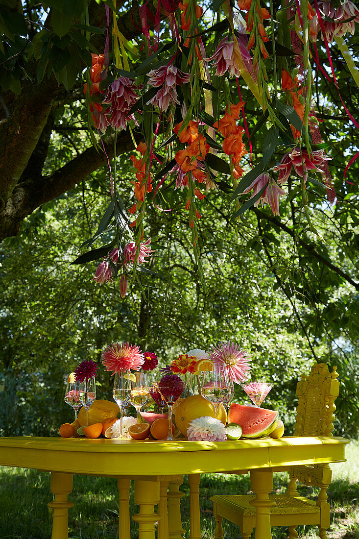 Tisch mit Dahlien und Früchten