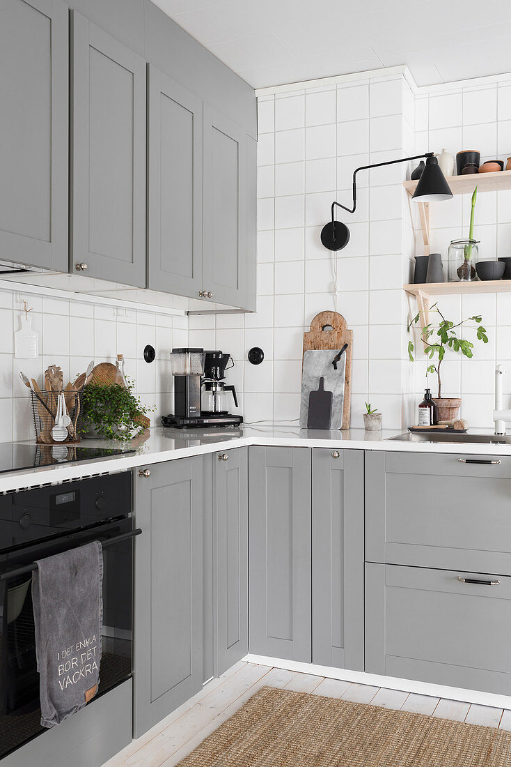 Küche im Landhausstil mit steingrauen Fronten und weißen Fliesenwänden
