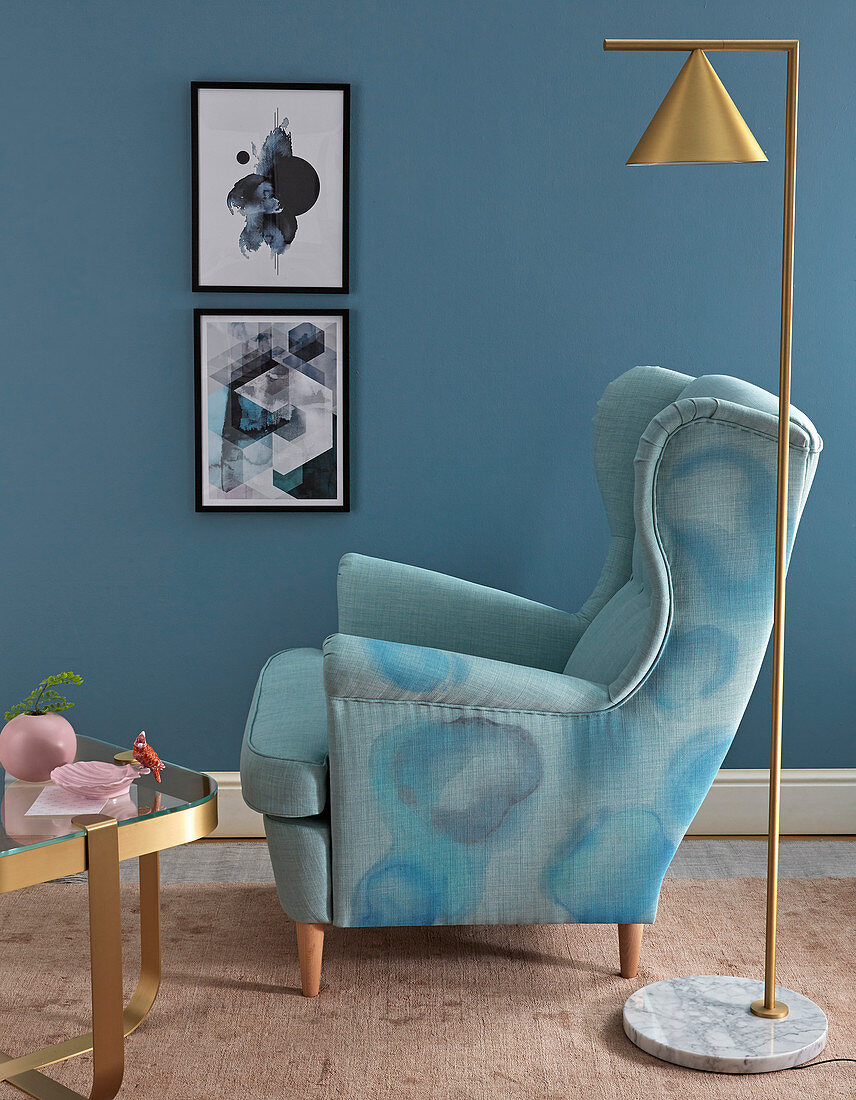 Watercolour effect on armchair upholstery painted with fabric paints against blue wall