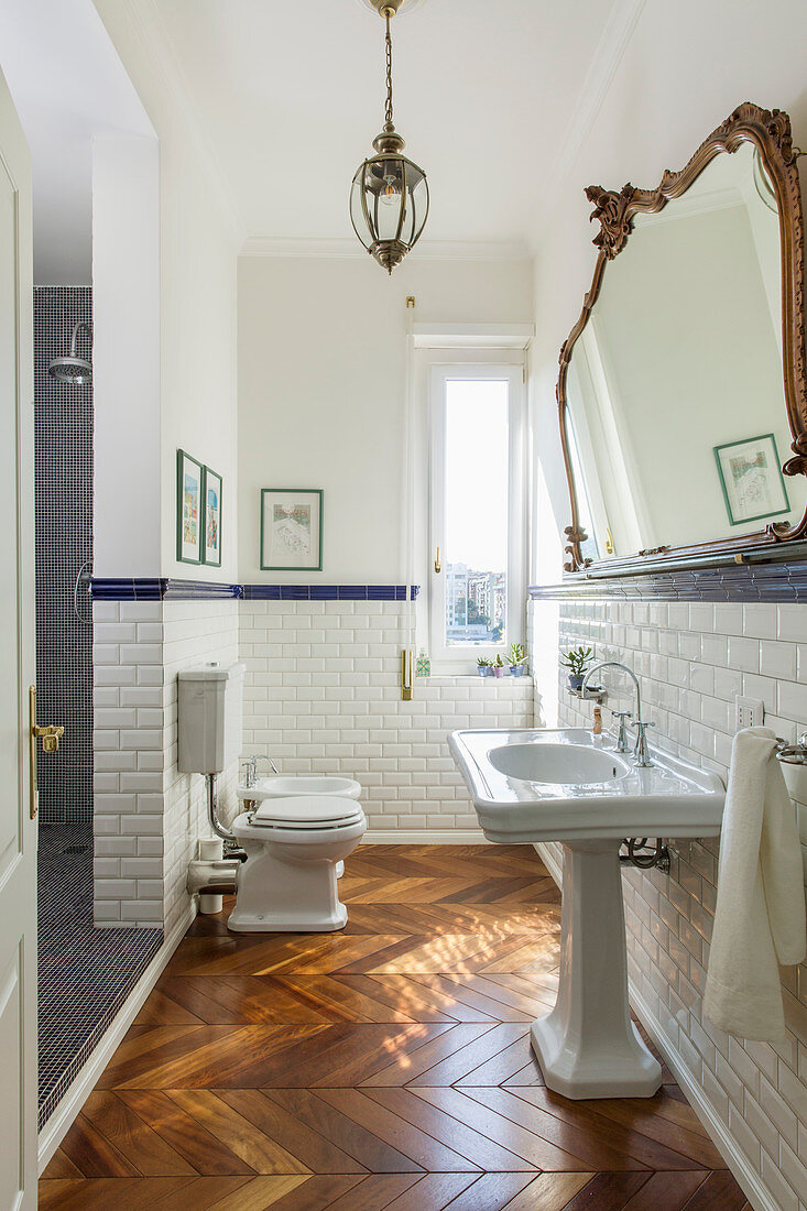 Classic bathroom with subway tiles and herringbone parquet floor in period building