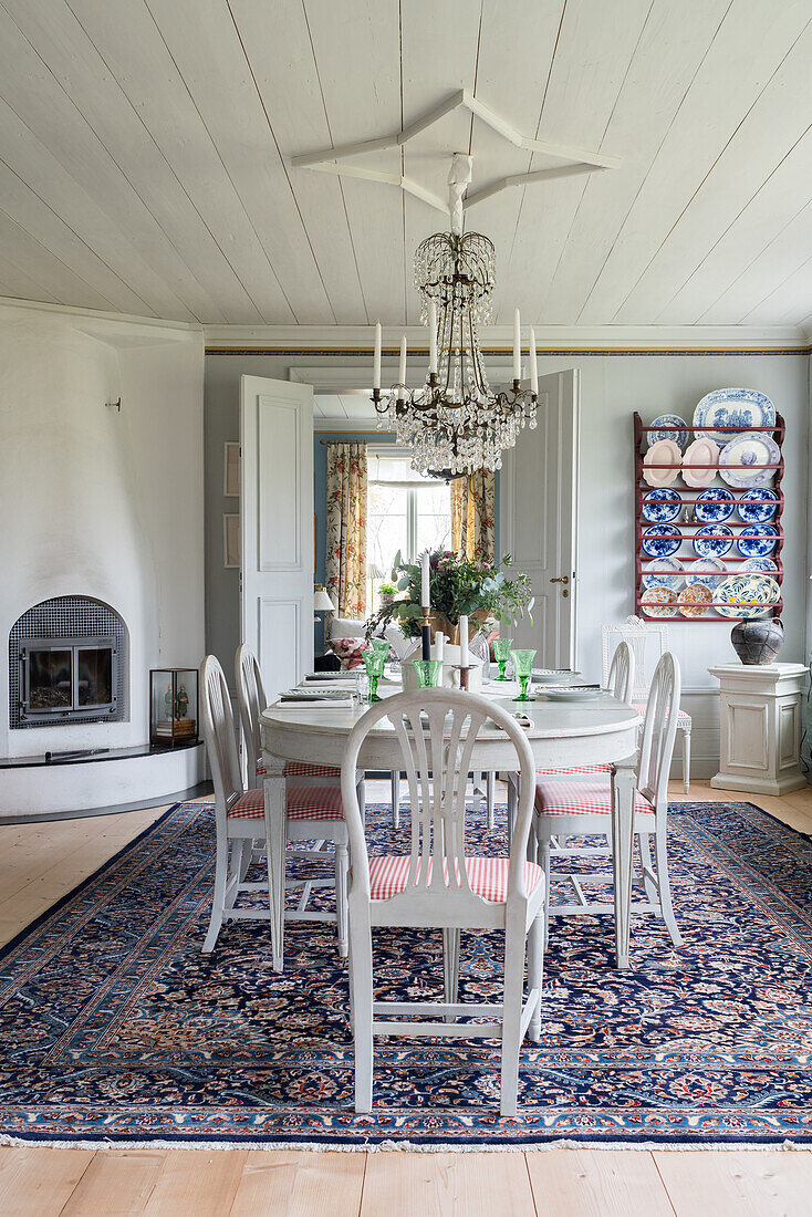 Fireplace, white furniture and Oriental rug in dining room of renovated Swedish house