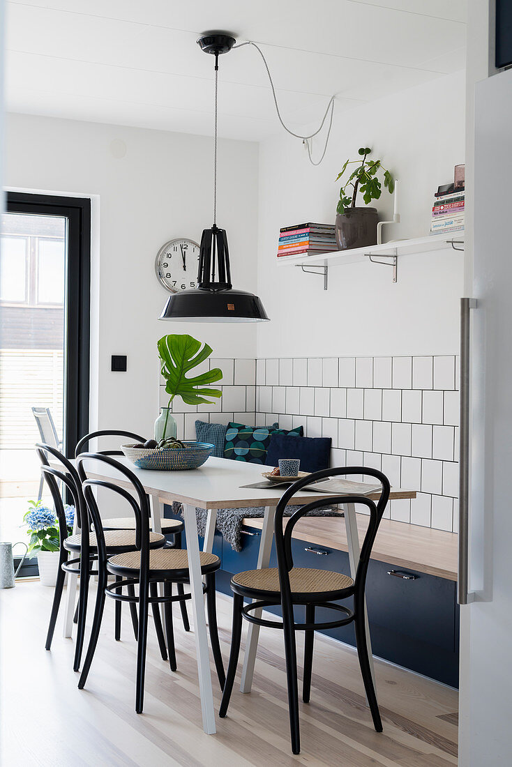 Tisch mit Bistrostühlen und blauer Sitzbank mit Stauraum in Küche