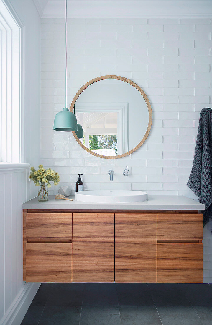 Vanity unit with wooden fronts in the white bathroom
