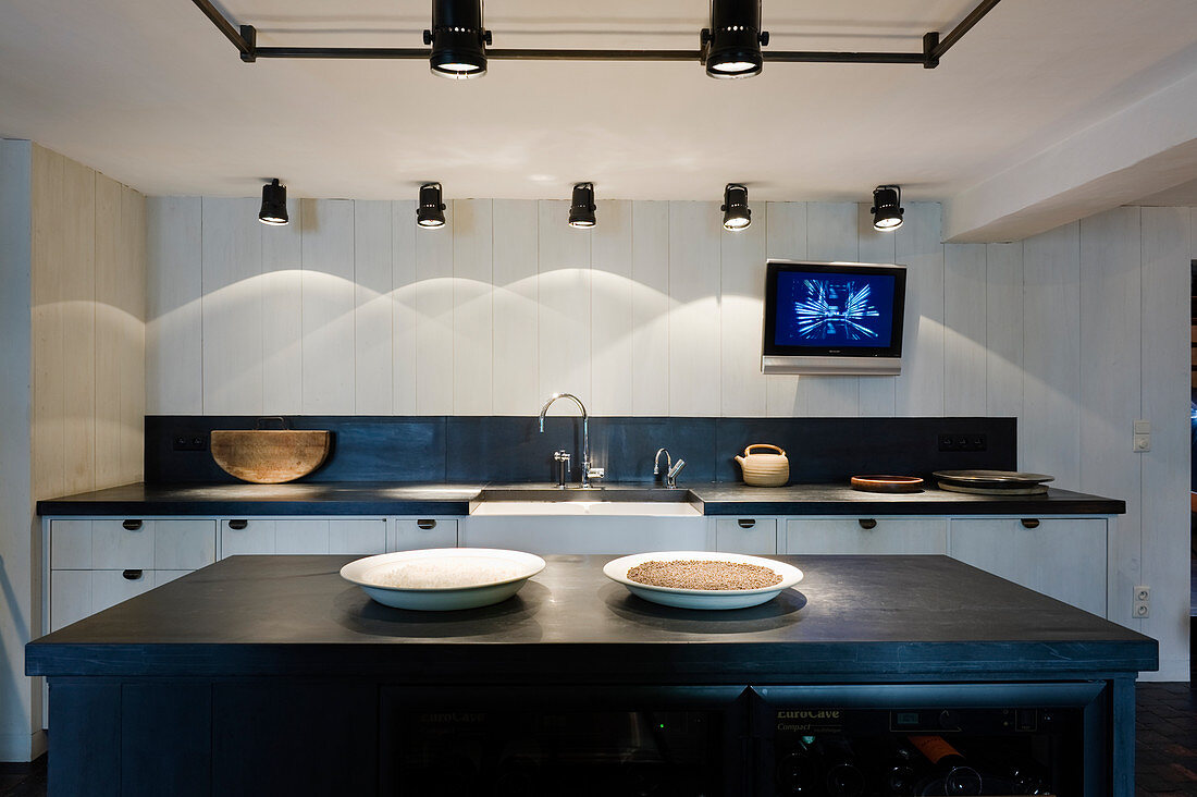 Island counter and various spotlights in black-and-white kitchen