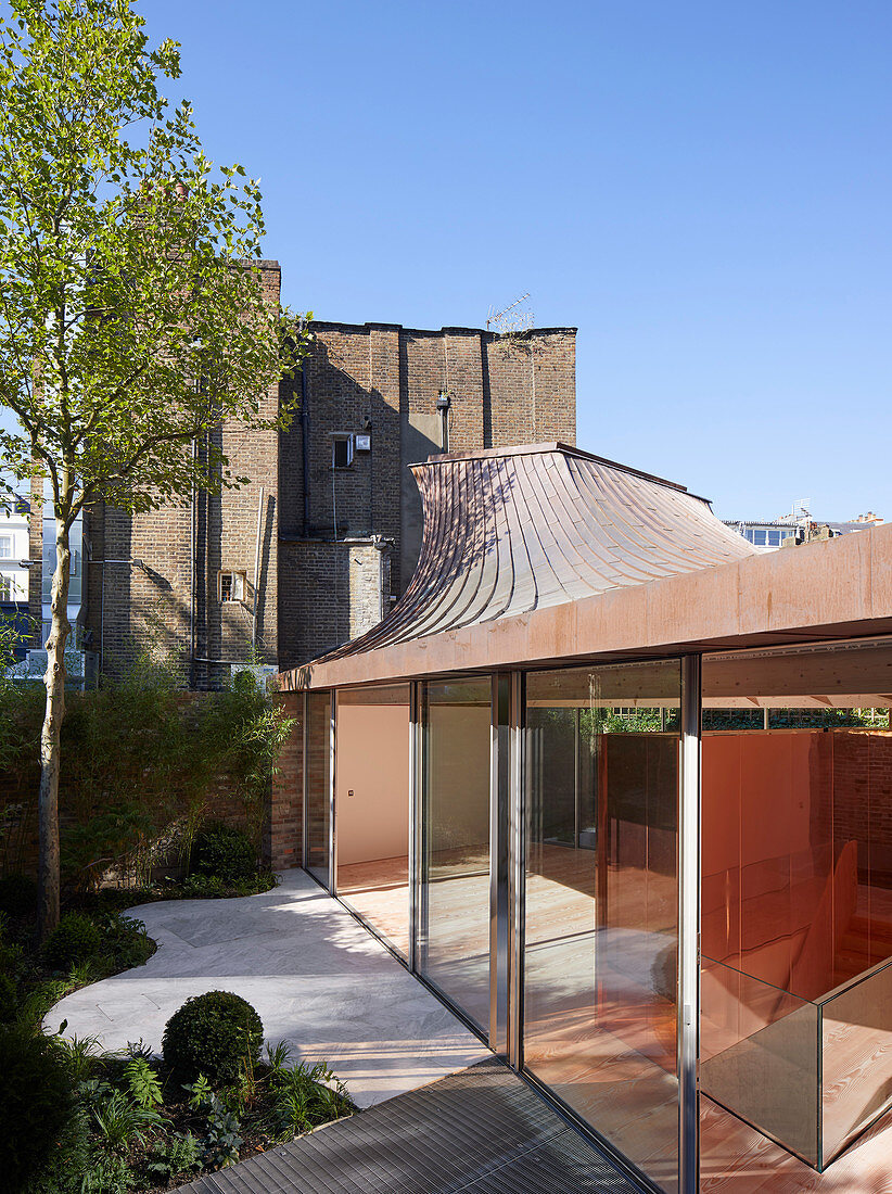 Modern extension with glass walls and funnel-shaped roof