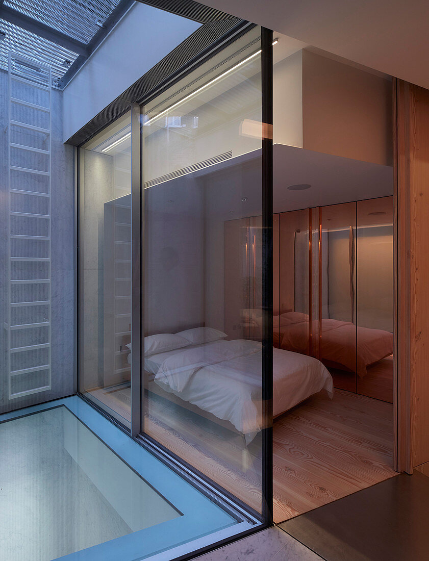 Blick ins minimalistische Schlafzimmer mit Verglasung