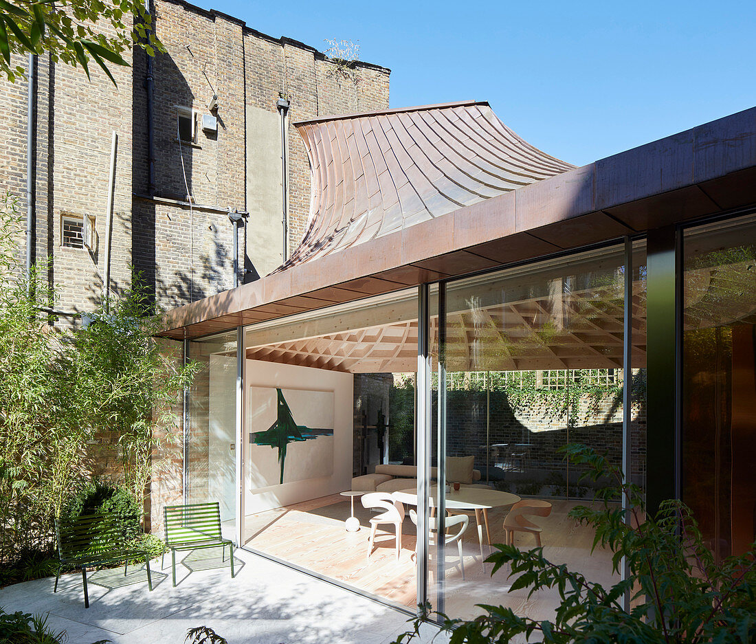 Modern extension with glass walls and funnel-shaped roof