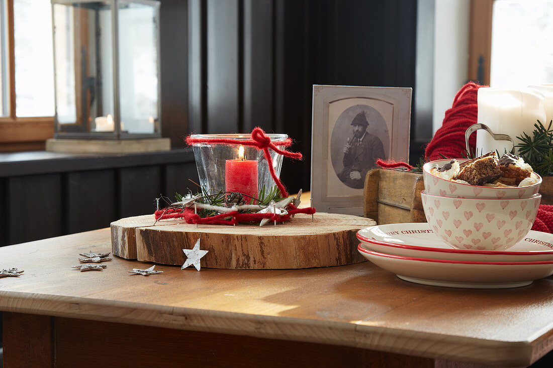 Weihnachtsdeko und Geschirr in Rot und Weiß auf einem Holztisch